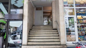 Un escalier menant à l’entrée d’un appartement, avec le numéro de porte, le 27, bien visible.
