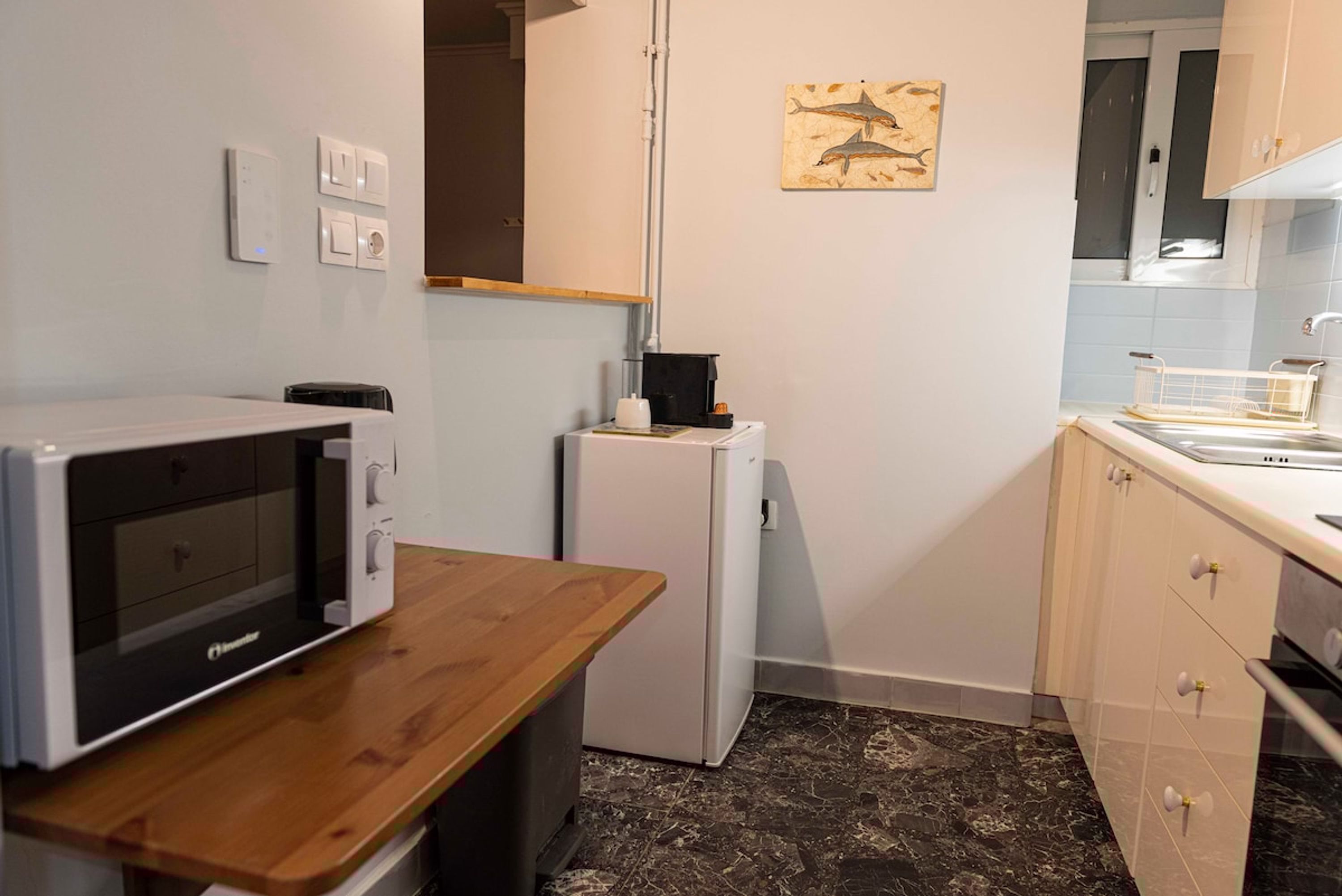 Une cuisine compacte équipée d’un four à micro-ondes, d’un réfrigérateur et d’un comptoir en bois.