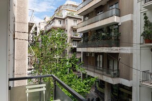Un immeuble résidentiel à plusieurs étages, doté de balcons, dont certains sont ornés de plantes.