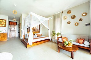 A room with a bed, a sofa, a coffee table with fruit, and decorative wall art. - Zanzibella Hotel & SPA (Kiwengwa)