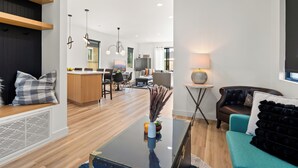 Ein modernes Wohnzimmer mit einer Couch, einem Couchtisch und einem Essbereich im Hintergrund.