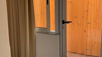 A sliding glass door leading to a wooden deck with a fence.