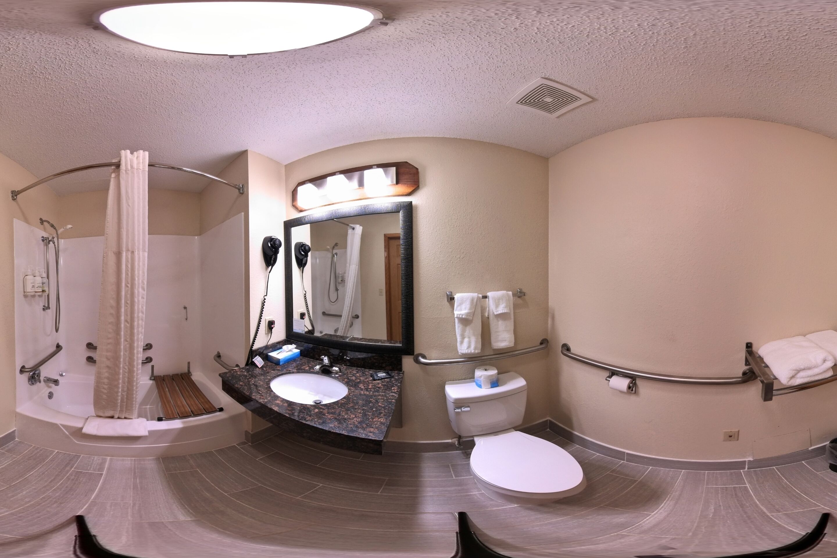 Un baño con ducha, inodoro, lavamanos y espejo.