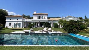 A large house with a swimming pool, lounge chairs, and a well-maintained lawn. - Villa Bonaventure, air-conditioned, Saint Tropez Golf Course, sleeps 14. Pool & Tennis Court   (Grimaud)