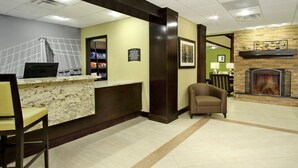 A hotel lobby with a reception desk, a fireplace, and a seating area. - ADA Studio Suite w/ Full Kitchen in Odessa (Odessa)