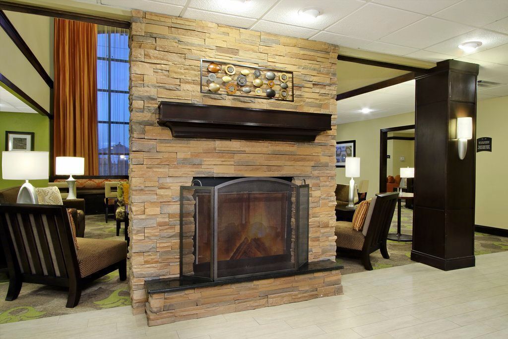 A lobby with a stone fireplace, seating area, and a view of the outdoors.