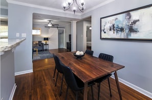 A dining area with a wooden table, black chairs, and a bowl of bread. - Charming 3BR Retreat in Plaza Close to Uptown (Charlotte)