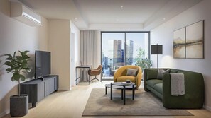 A modern living room with a sofa, a coffee table, a TV, and a large window with a city view.