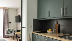 Una cucina moderna con mobili scuri, un piano di lavoro in legno e una ciotola di frutta.
