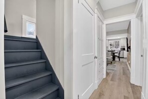 Ein modernes Interieur mit Treppe, Küchenbereich und Essplatz.