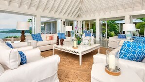 A spacious living room with white furniture, a white ceiling, and a view of the ocean. - Private 2BR Open-air Villa Panoramic Views Pool (Montego Bay)