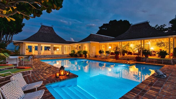 A swimming pool with lounge chairs and a covered area with potted plants. - Private 2BR Open-air Villa Panoramic Views Pool (Montego Bay)