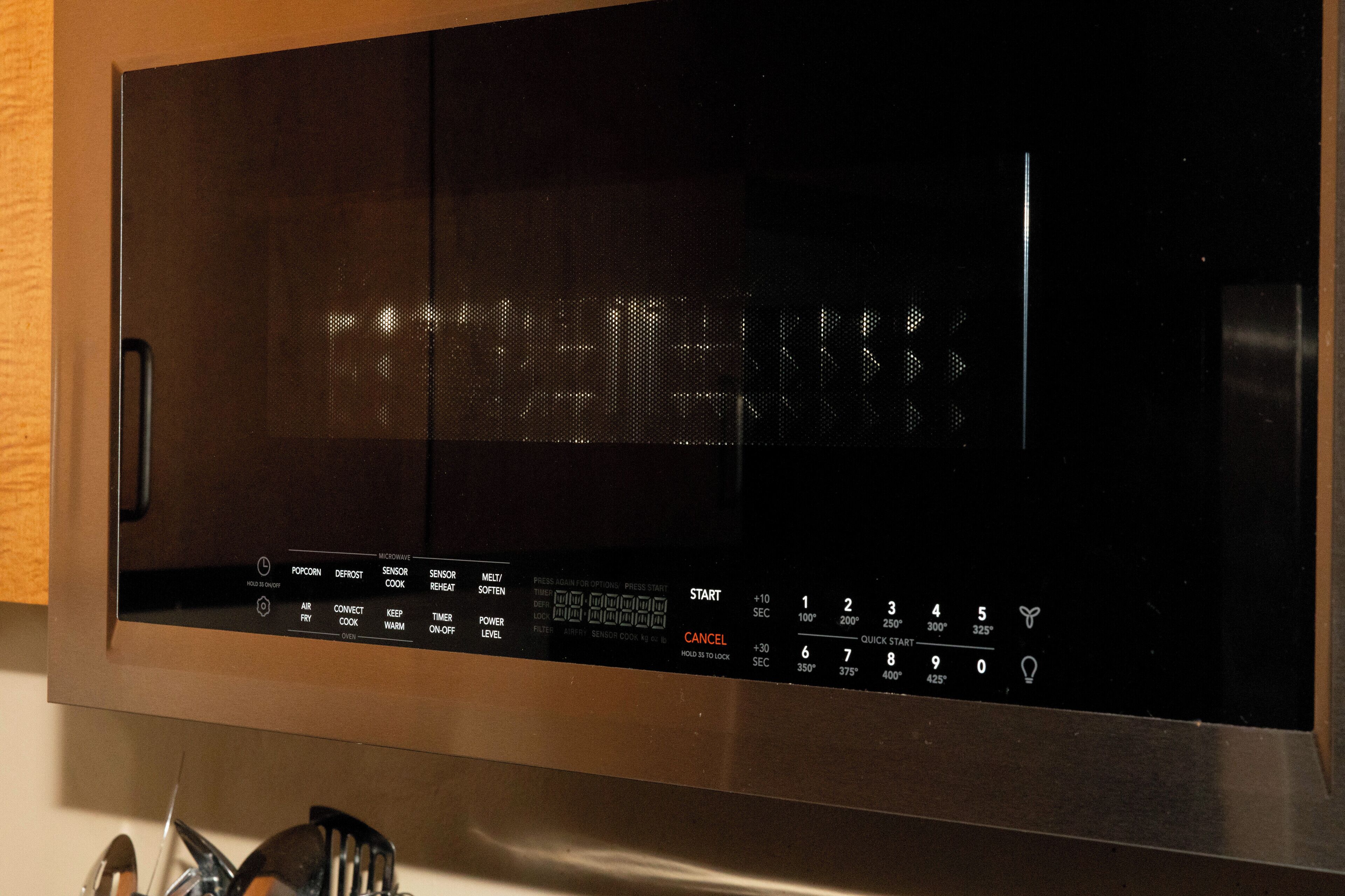 Un microondas con pantalla digital y panel de control.