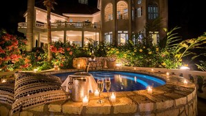 A luxurious pool area with a stone edge, a hot tub, and candles. - Sprawling 7BR Villa Overlooking the Sea Pool Hot Tub Resort Access (Montego Bay)
