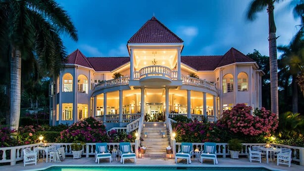 A large, multi-story house with a central balcony, a swimming pool, and lush landscaping. - Sprawling 7BR Villa Overlooking the Sea Pool Hot Tub Resort Access (Montego Bay)