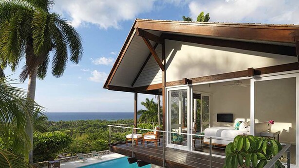 A modern house with a pool, outdoor furniture, and a view of the ocean. - Nature-inspired 4BR Modern Villa Pool Resort Access (Montego Bay)