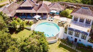 Une grande maison avec une piscine, de nombreuses pièces et un jardin.