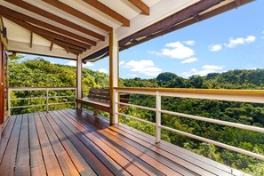 A wooden deck with a bench, white railings, and a view of a forested hillside. - Hidden 4BR Gem Pool Nature Escape in the Hills of Port Antonio (Port Antonio)