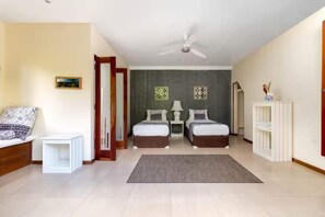 A bedroom with two beds, a ceiling fan, a bedside table, a nightstand, a rug, and a wall-mounted shelf. - Hidden 4BR Gem Pool Nature Escape in the Hills of Port Antonio (Port Antonio)