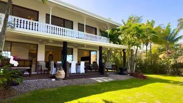 A two-story hotel with a covered patio area and a well-maintained lawn.
