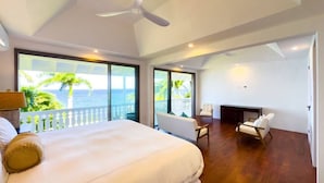 A spacious bedroom with a large bed, a ceiling fan, and a view of the ocean through large windows. - 4BR Seafront Villa in Boscobel Direct Sea Access Coastal Living (Boscobel)