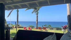 A room with a view of the ocean, a grassy area with red chairs, and a large window. - 4BR Seafront Villa in Boscobel Direct Sea Access Coastal Living (Boscobel)