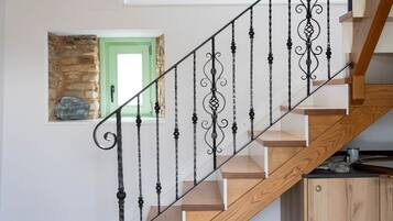 Una escalera con barandilla de madera y balaustres negros.