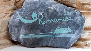 Uma pedra com a inscrição “La Románica” e uma ilustração de barco.
