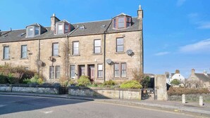 A two-story stone building with multiple windows, a flat roof, and satellite dishes. - Milton Apartment - 3 Beds, Kirkcaldy with sea view (Fife)