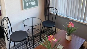 Ein Zimmer mit Holztisch, zwei Stühlen, einem Blumentopf und einem Schild an der Wand mit Hotel- und Museumnamen.