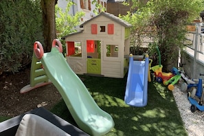 A children's play area with a slide, a small house, and toy vehicles. - Boho Room with Garden and Private Jacuzzi (Villages du Lac de Paladru)