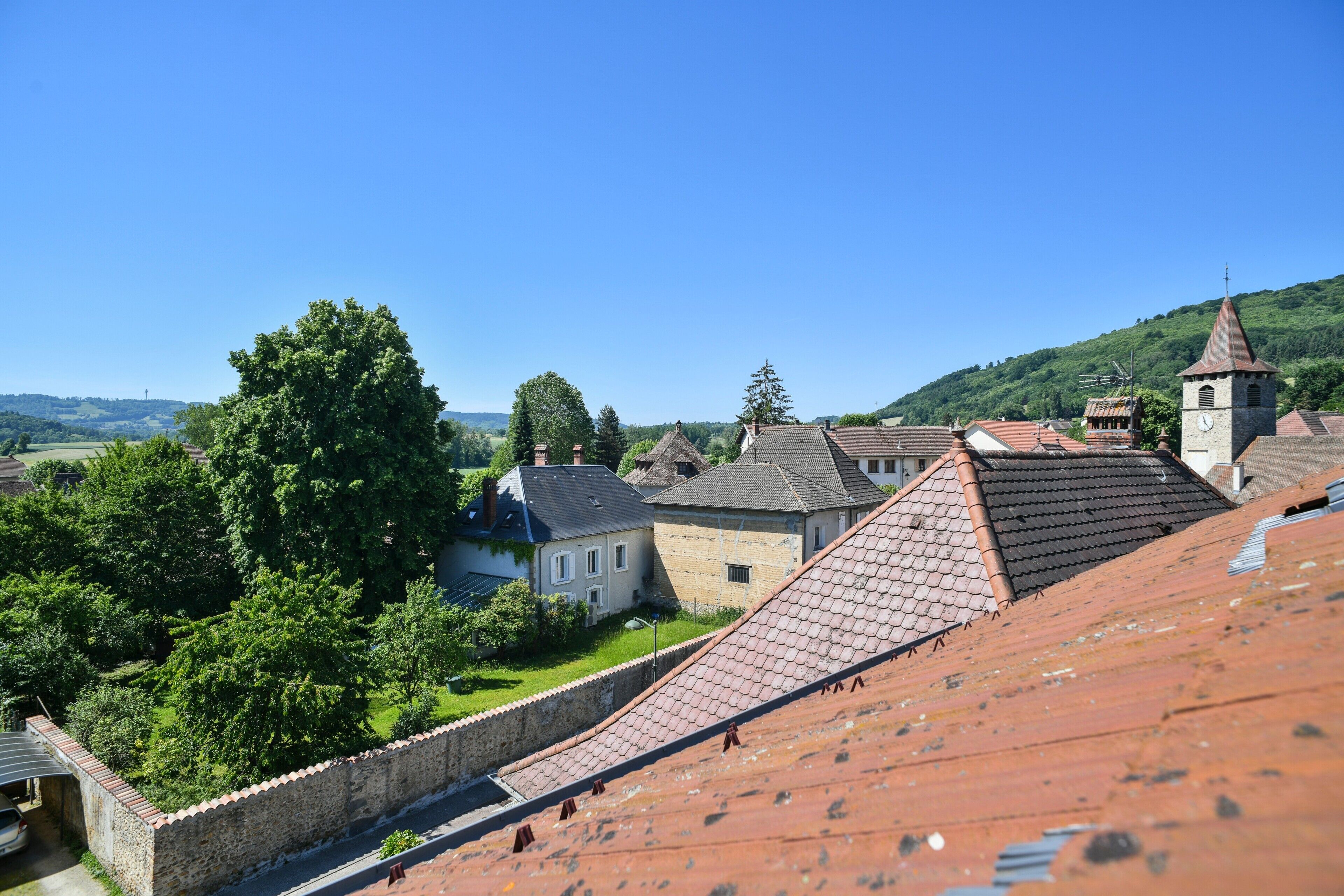 Une ville qui possède des bâtiments historiques, un clocher d’église et un mur de pierre.