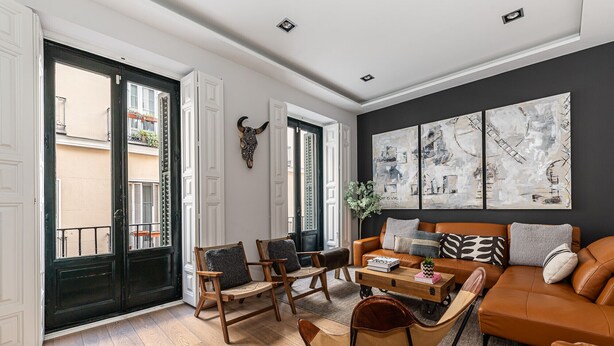 A modern living room with a sofa, chairs, a coffee table, and artwork on the wall. - Waou Justice V - Short Term Rental (Madrid)