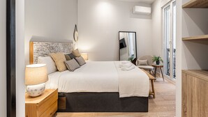 A modern bedroom with a large bed, bedside tables, a mirror, and a view of the outside balcony. - Waou Justice V - Short Term Rental (Madrid)