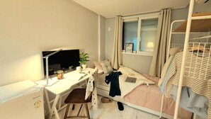 A bedroom with a desk, a bed, a window, and a bunk bed. - Dodahm Guesthouse (Incheon)