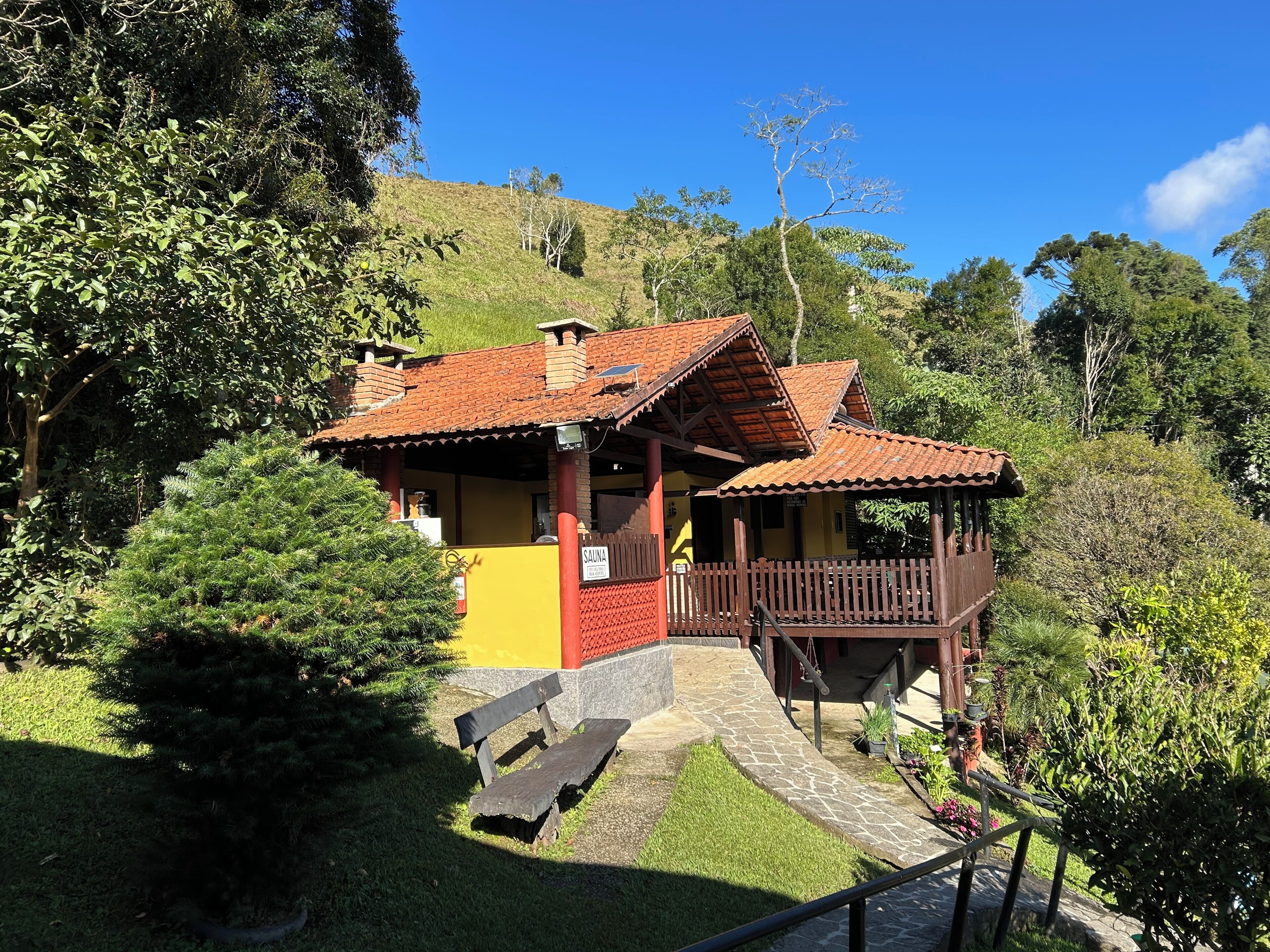 A building with a red roof, a yellow wall, and a wooden deck.
