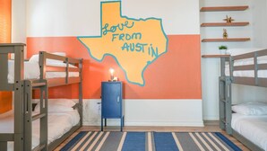 A room with bunk beds, a wall mural of Texas, a small blue cabinet, and a striped rug. - 5 STAR BIG Group FUN ~BACH / Family Trip (Austin)