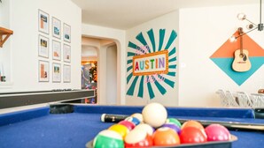 A pool table with colorful balls, a framed picture collection on the wall, and a neon sign that reads "AUSTIN". - 5 STAR BIG Group FUN ~BACH / Family Trip (Austin)