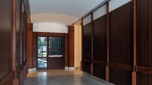 Un pasillo con paneles de madera y un vidrio que da a un balcón.