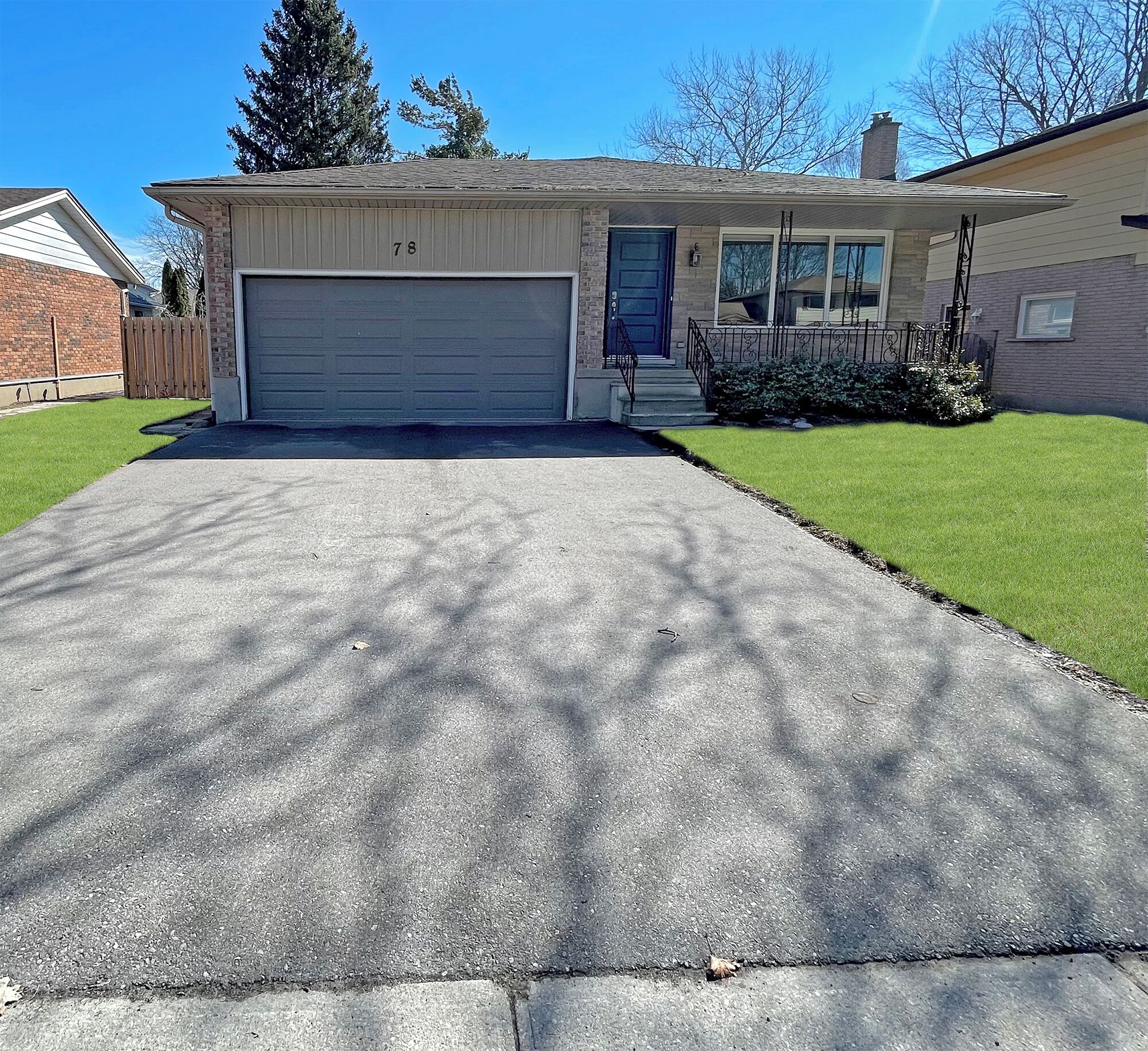 A single-story house with a garage, a front door, and a small front yard.