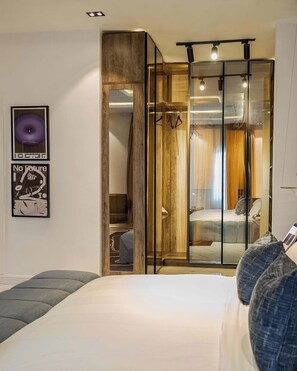 A bedroom with a bed, a bench, a wardrobe, and a mirror. - TRUTH STAYS (Abuja)