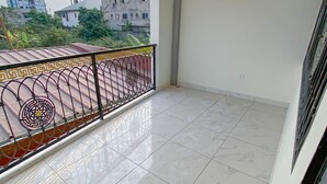 Un balcon doté d’un sol carrelé et d’une rambarde en métal décorative.