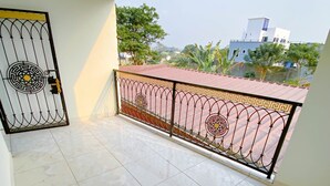 Un balcón con piso de baldosas y una reja decorativa de metal.