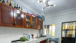 Une cuisine avec des meubles en bois, un évier en acier inoxydable, un four à micro-ondes et un réfrigérateur.