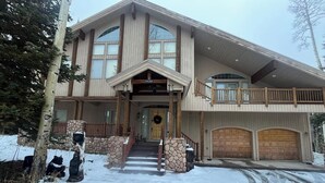 A large, two-story house with a stone entrance, a covered porch, and a garage. - True Ski In/Out on Maryland Parkway Trail Chair #4 (Brian Head)