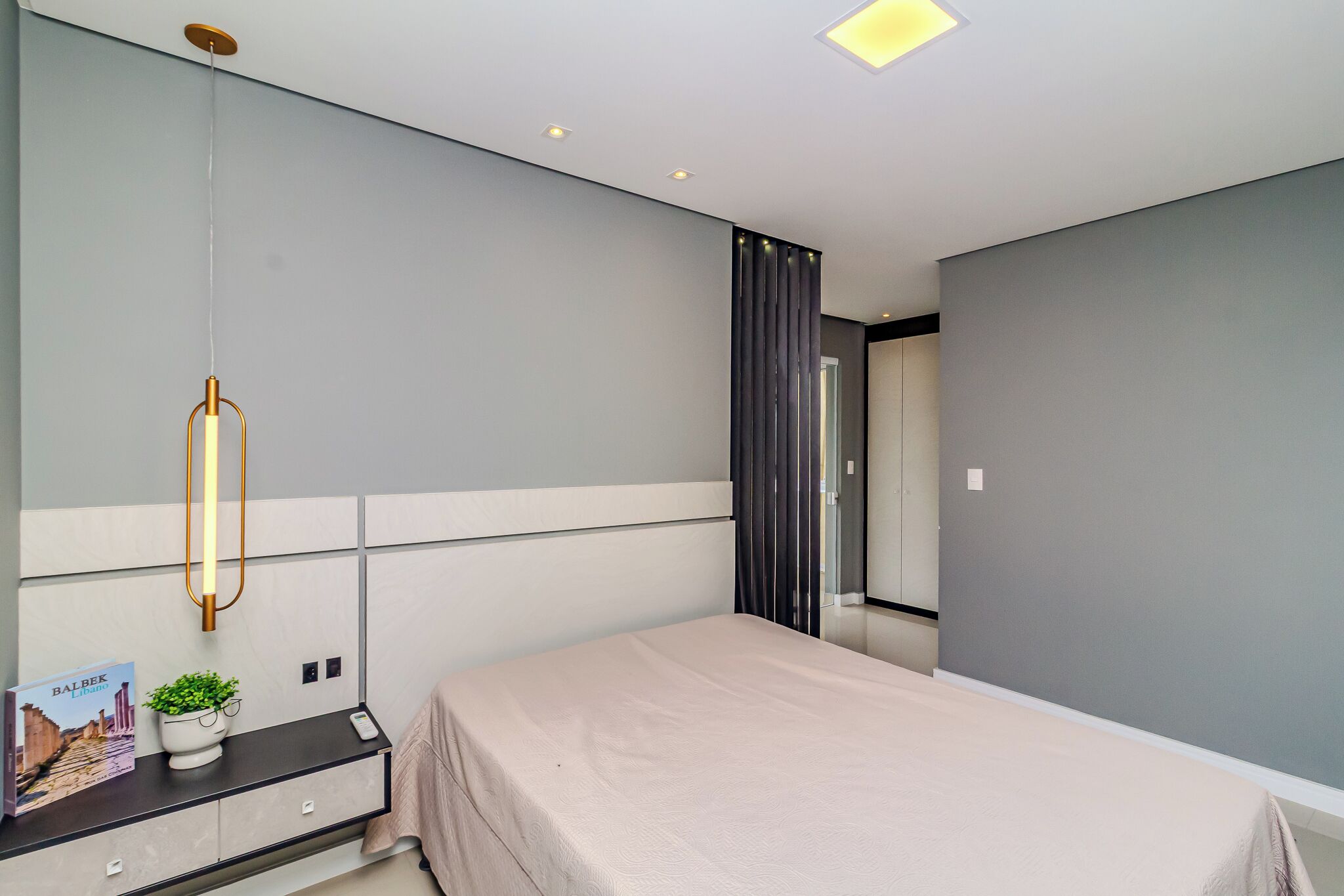 Ein modernes Schlafzimmer mit Bett, Nachttisch und Spiegel.