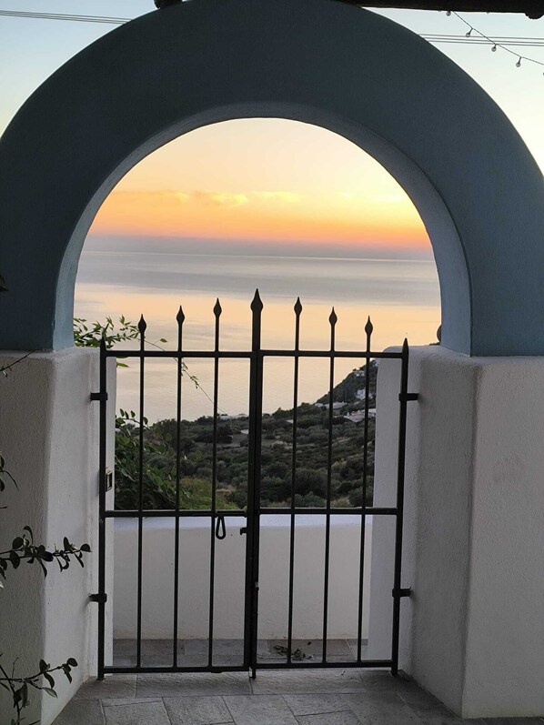 Una entrada vigilada con vistas al mar al atardecer.