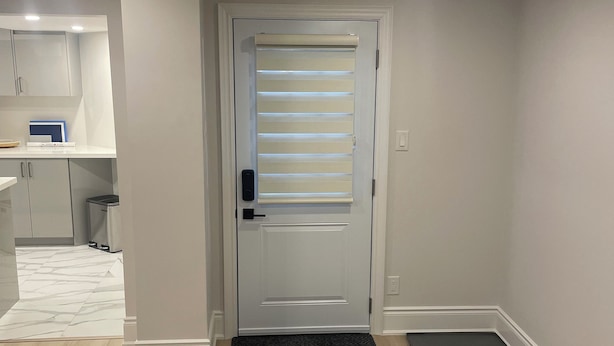 A modern, well-lit entryway with a door, a small kitchen area, and a wooden floor. - Spacious Basement Apartment in Rouge Hill Near Highway 401 (Toronto)