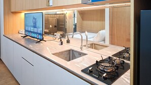 Et moderne køkken med indbygget komfur, en dobbeltvask og et digitalt display.