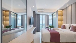 Une chambre d’hôtel moderne dotée d’un grand lit, d’une table de chevet, d’une télévision et d’une grande fenêtre donnant sur la ville.